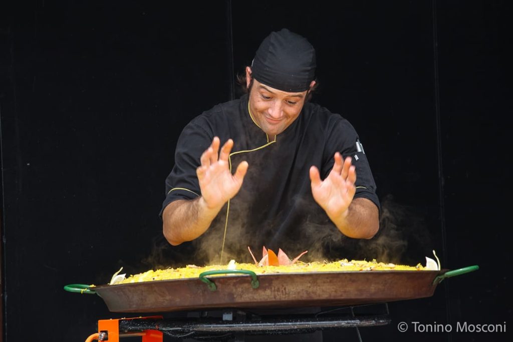 Fotografia di Tonino Mosconi ritraente un cuoco che osserva orgoglioso la propria preparazione